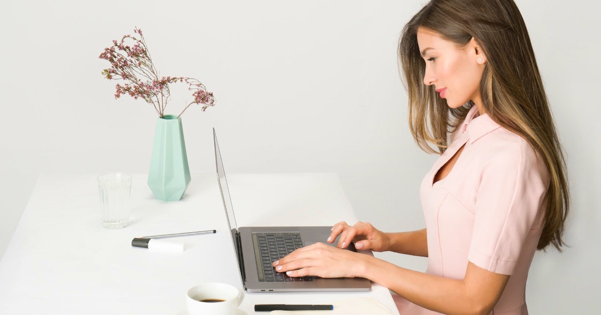 パソコンに向かい仕事をしている女性の画像